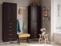 A tidy and coordinated bathroom interior featuring John Louis Home solid wood storage towers a wooden bench with a yellow cushion, and decorative items on a small table, like a potted plant and books.