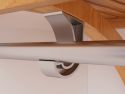 Close-up view of a John Louis Home garment bar J hook connecting an angle bracket, shelf and garment bar highlighting the smooth satin nickel metal and wood finish.