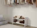 A organized closet with a variety of shoes neatly placed on an easily accessible on a solid wood shoe rack and clothes hanging on the wall.