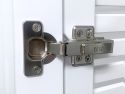 Close-up of a John Louis Home son close door hinge attached to white Shaker-style cabinet doors, showing visible branding and screws.