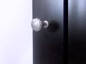 Close-up of a John Louis Home satin nickel doorknob on an solid wooden door.