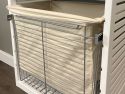 A John Louis Home 20 inch deep wire laundry basket with a canvas liner installed within a solid wood storage tower that keeps your laundry organized