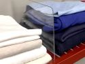 Angled closeup view of a clear John Louis Home shelf divider that helps organize your clothes on a shelf