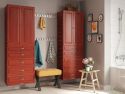 A tidy and coordinated bathroom interior featuring John Louis Home solid wood storage towers a wooden bench with a yellow cushion, and decorative items on a small table, like a potted plant and books.