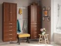 A tidy and coordinated bathroom interior featuring John Louis Home solid wood storage towers a wooden bench with a yellow cushion, and decorative items on a small table, like a potted plant and books.
