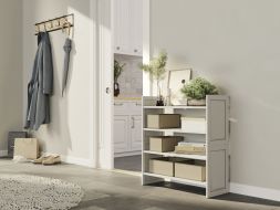 A 2 tiered stackable storage shelf with baskets, decor items and books, creating a neat and organized storage solution displayed in the hallway of a refreshing home.