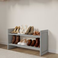 A neatly organized closet with a variety of shoes easily accessible on a grey solid wood shoe rack and clothes hanging on the wall.