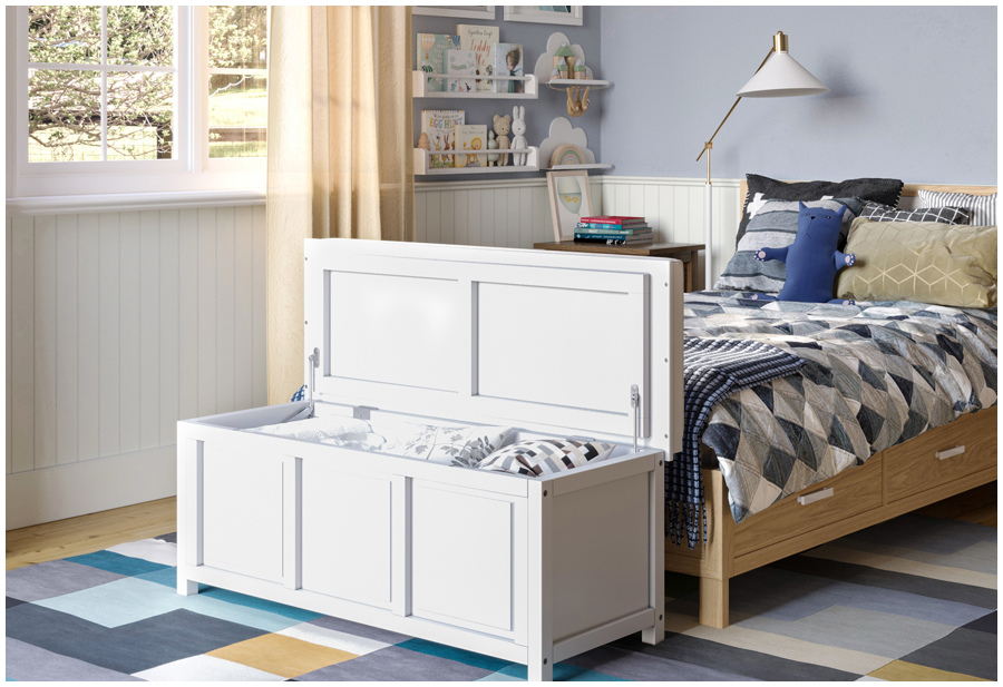 A white wooden storage bench sits at the foot of a bed in a kid's bedroom.