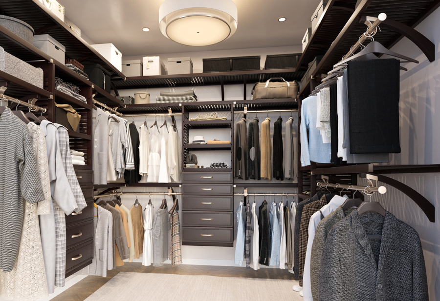 A customer's walk-in closet designed by John Louis Home featuring a variety of clothing items, footwear, and accessories.